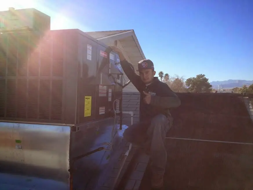 HVAC technician performing Heat Pump Repair on a rooftop unit in Rosaryville