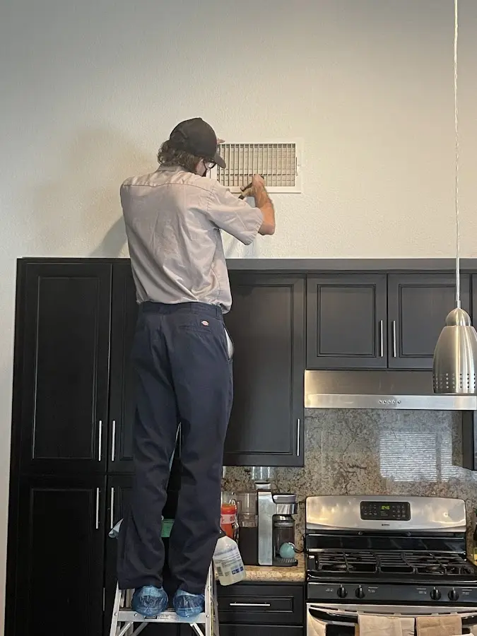 Technician inspecting an air vent during HVAC service in Rosaryville